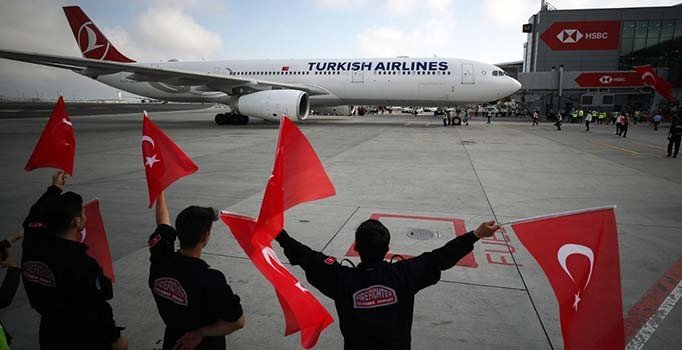 A Milliler havalimanında bayraklarla karşılandı