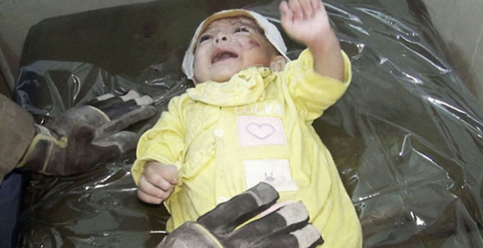 Suriye'nin İdlib şehrinde uçaklarının harabeye çevirdiği binanın enkazından 1 aylık bebek sağ çıktı