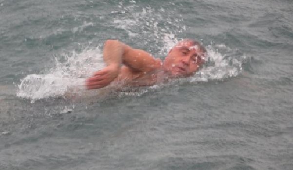 Kar ve soğuk havaya aldırmadan denizde yüzdü