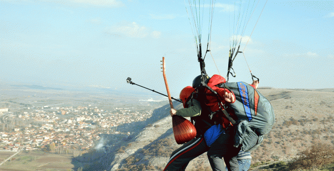 Yamaç paraşütüyle saz çalıp türkü söyledi