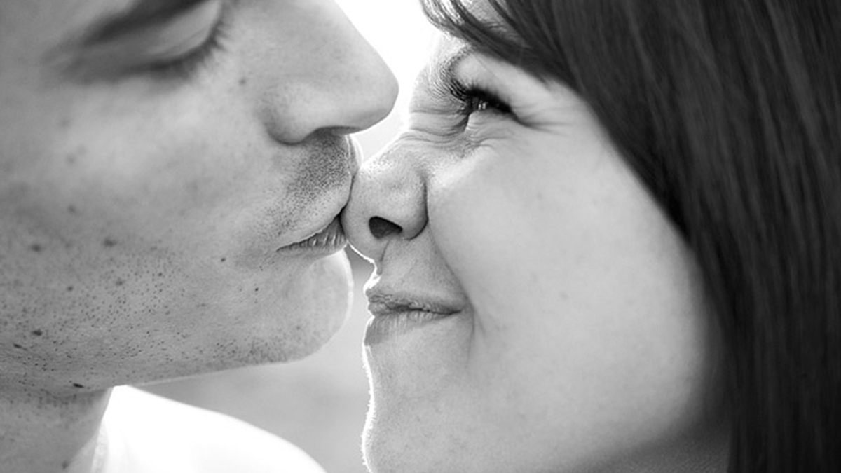 Игриво ласково. Девушка целует парня в щечку. Нежный поцелуй. Нежный поцелуй в нос. Нежный поцелуй в щеку.