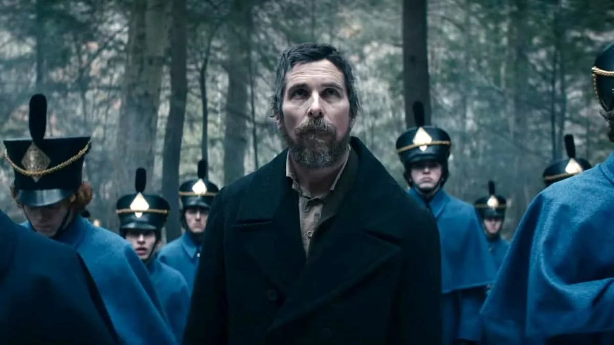 christian-bale-in-the-woods-in-the-pale-blue-eye.webp